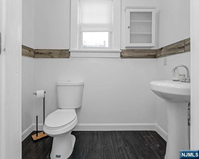 bathroom with hardwood / wood-style floors, built in shelves, sink, and toilet