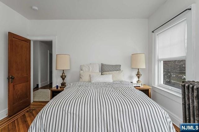 bedroom with dark wood-type flooring