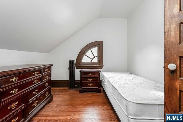 bedroom featuring lofted ceiling and dark wood-type flooring