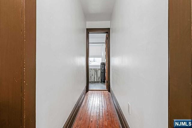 hallway with hardwood / wood-style flooring