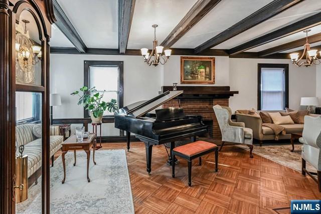 miscellaneous room featuring beamed ceiling, light parquet floors, and a notable chandelier