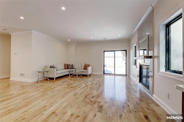 living room featuring light wood-type flooring and crown molding