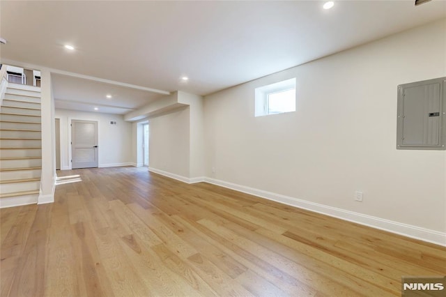 interior space featuring electric panel and light hardwood / wood-style flooring