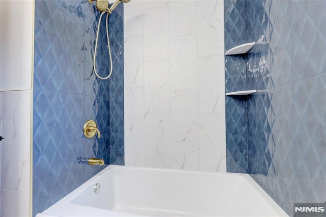 bathroom featuring tiled shower / bath