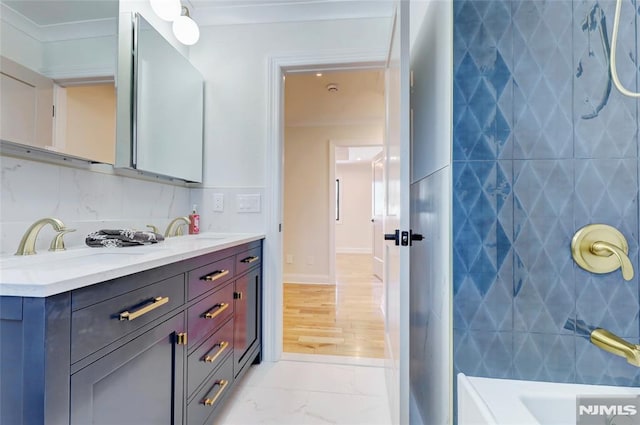 bathroom featuring plus walk in shower, vanity, crown molding, and tasteful backsplash