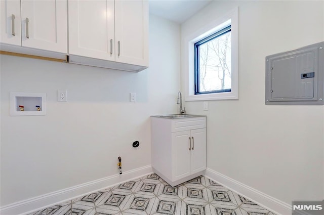 clothes washing area featuring sink, hookup for a washing machine, hookup for a gas dryer, electric panel, and cabinets