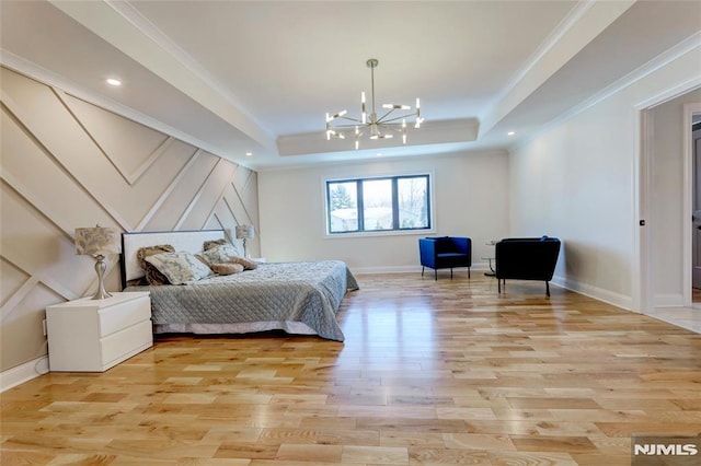 bedroom featuring a tray ceiling, light hardwood / wood-style flooring, and a chandelier