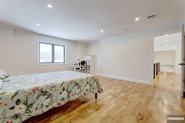 bedroom with crown molding and light hardwood / wood-style floors