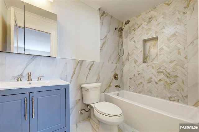 full bathroom featuring toilet, tiled shower / bath combo, tile walls, decorative backsplash, and vanity