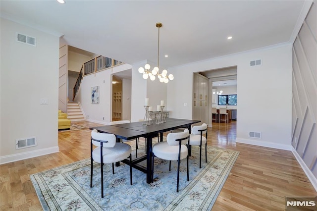 dining area with ornamental molding, an inviting chandelier, and wood-type flooring