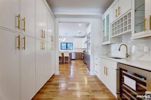 kitchen with sink, white cabinetry, wine cooler, and stainless steel appliances