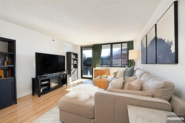 living room with a textured ceiling and light wood-type flooring