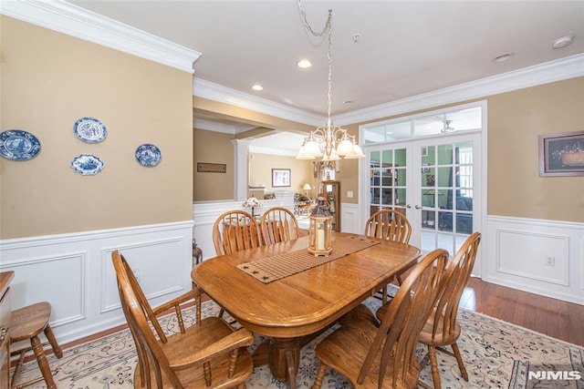 dining room featuring french doors, ornamental molding, and light hardwood / wood-style floors