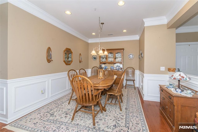 dining room with light wood-type flooring, a chandelier, and ornamental molding