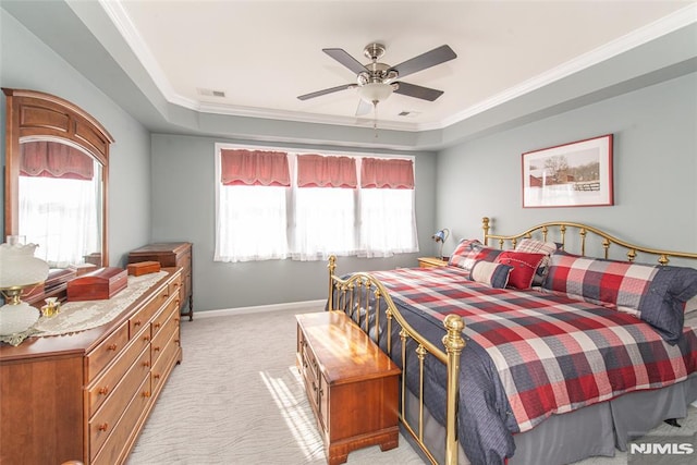 carpeted bedroom featuring ceiling fan, crown molding, and a tray ceiling