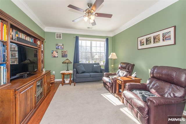 living room with light wood-type flooring, ceiling fan, and ornamental molding