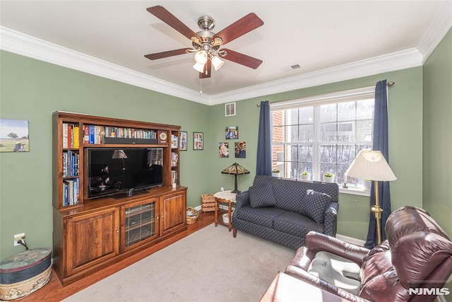 carpeted living room featuring ceiling fan and crown molding