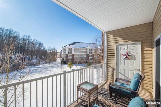 view of snow covered back of property