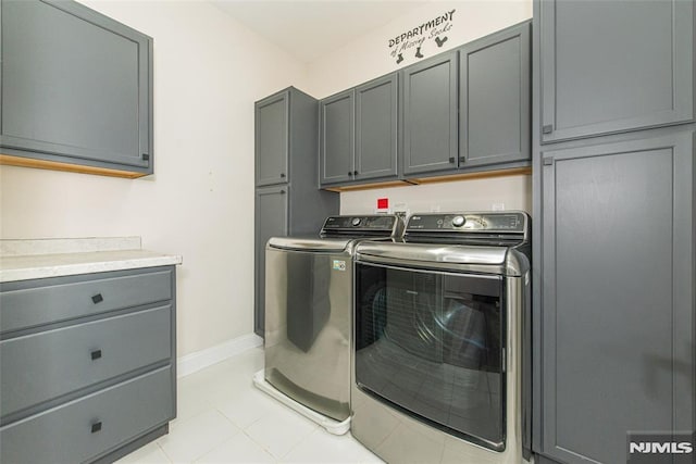 washroom with cabinets and washing machine and clothes dryer