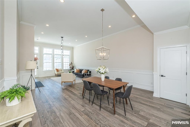 dining room with ornamental molding, wood-type flooring, and a chandelier