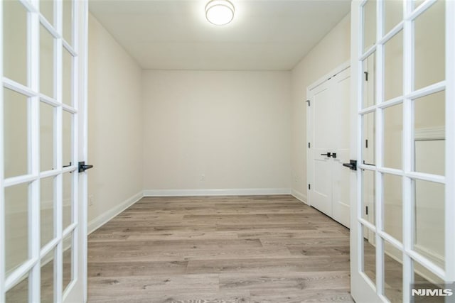 empty room featuring light wood-type flooring and french doors