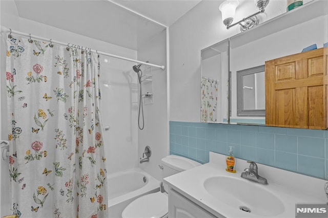 full bathroom featuring vanity, toilet, shower / bath combo with shower curtain, and decorative backsplash