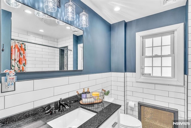 bathroom featuring tile walls, radiator, toilet, vanity, and a shower with shower curtain