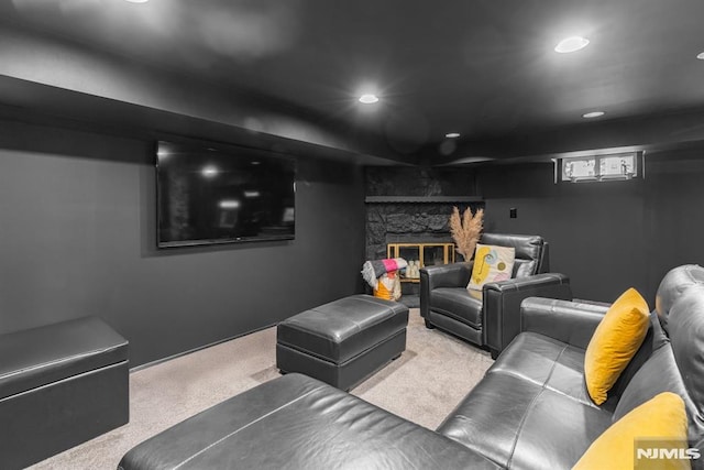 home theater with a stone fireplace and carpet