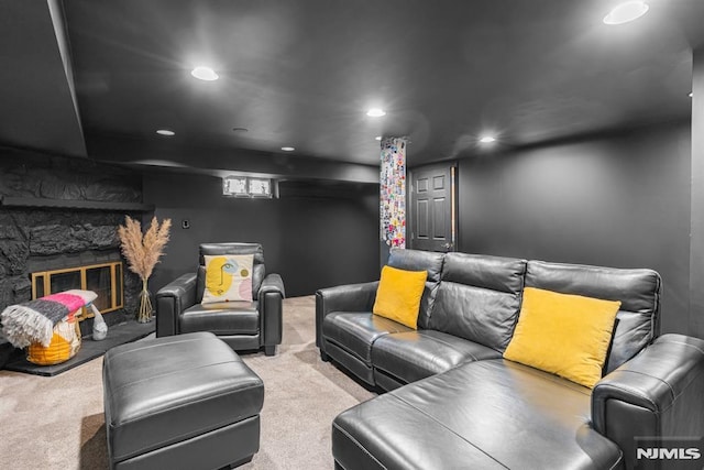 carpeted home theater room featuring a fireplace