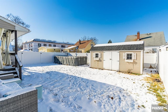 yard covered in snow with a storage unit