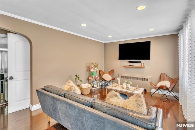 living room featuring hardwood / wood-style flooring, radiator heating unit, and ornamental molding