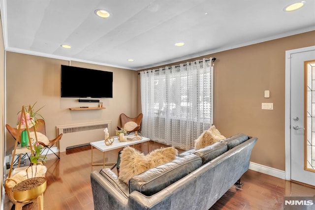 living room featuring radiator heating unit, hardwood / wood-style flooring, and ornamental molding