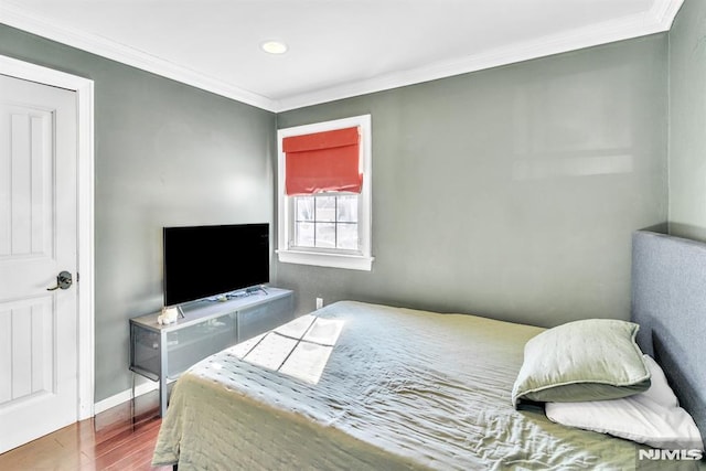 bedroom featuring hardwood / wood-style floors and crown molding