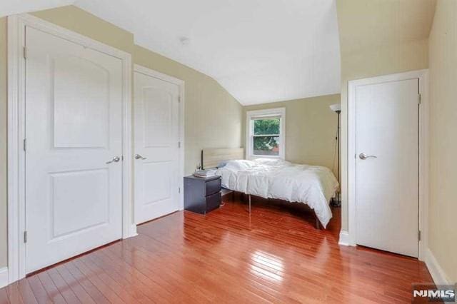 bedroom featuring vaulted ceiling and hardwood / wood-style floors