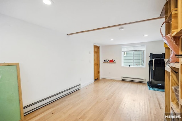 living room with light hardwood / wood-style floors and a baseboard heating unit