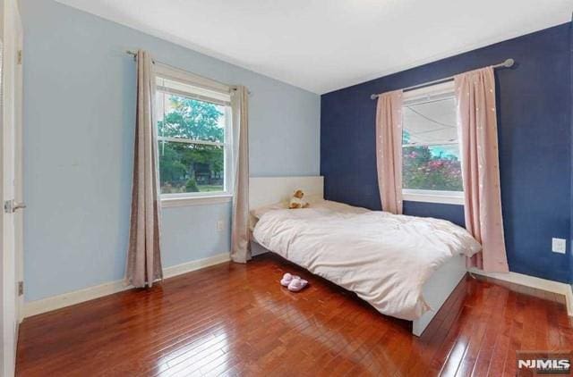 bedroom with dark hardwood / wood-style floors