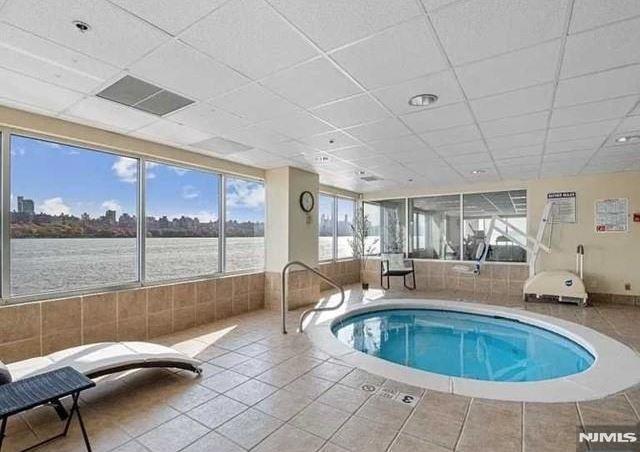 view of swimming pool featuring a jacuzzi and a water view