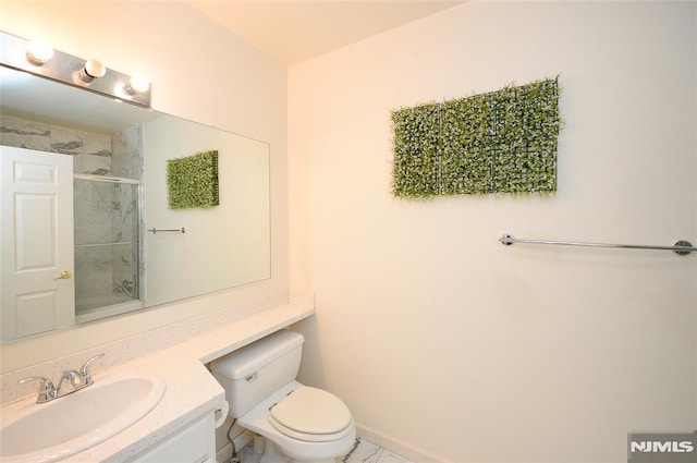 bathroom featuring vanity, a shower with shower door, and toilet