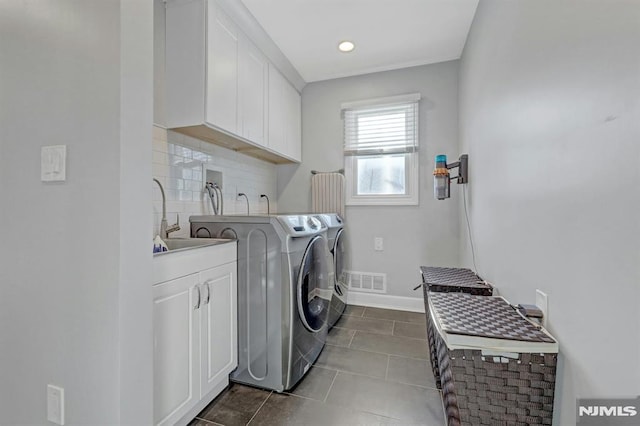 laundry area with cabinets, separate washer and dryer, tile patterned floors, and sink