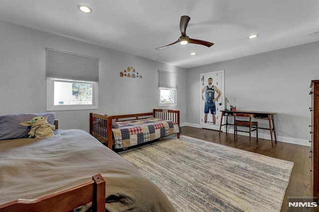 bedroom featuring multiple windows, dark wood-type flooring, and ceiling fan