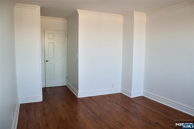 spare room featuring ornamental molding and dark hardwood / wood-style flooring