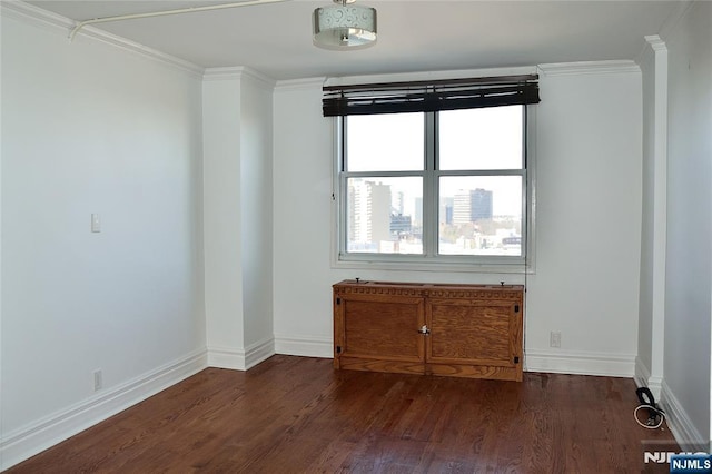 spare room featuring dark wood-type flooring and ornamental molding