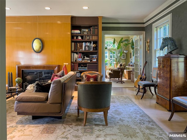 sitting room featuring hardwood / wood-style flooring, a wealth of natural light, and ornamental molding