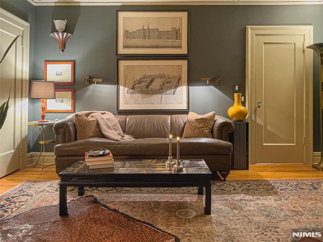 sitting room with wood-type flooring and ornamental molding