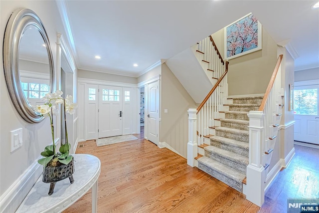 foyer entrance featuring crown molding and light hardwood / wood-style floors