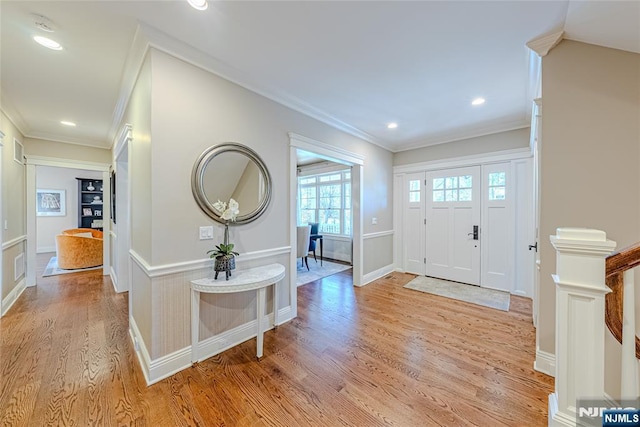 foyer entrance featuring crown molding and light hardwood / wood-style floors