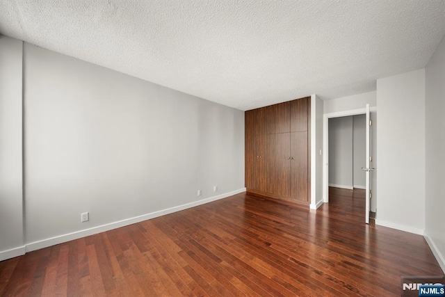 unfurnished bedroom with dark wood-type flooring, a closet, and a textured ceiling