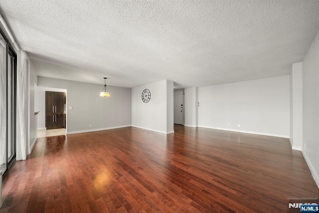 unfurnished living room featuring a textured ceiling and dark hardwood / wood-style flooring