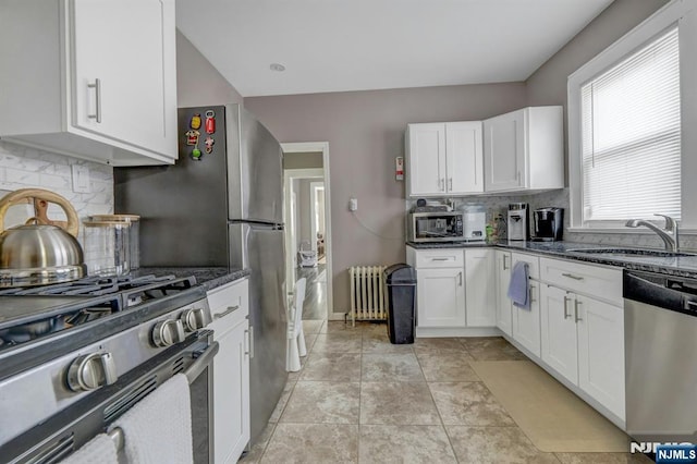 kitchen with white cabinetry, sink, radiator heating unit, and stainless steel appliances