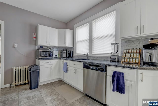 kitchen with sink, white cabinetry, dark stone countertops, radiator, and stainless steel appliances